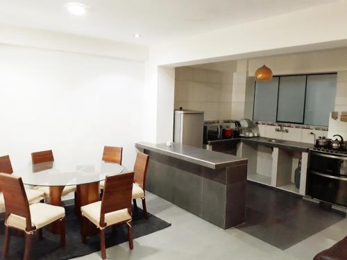 瓦拉斯Alojamiento Huaraz的一间带桌子和椅子的大厨房