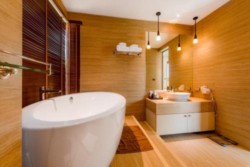 a bathroom with a white tub and a sink at Triple Tree Beach Resort in Cha Am