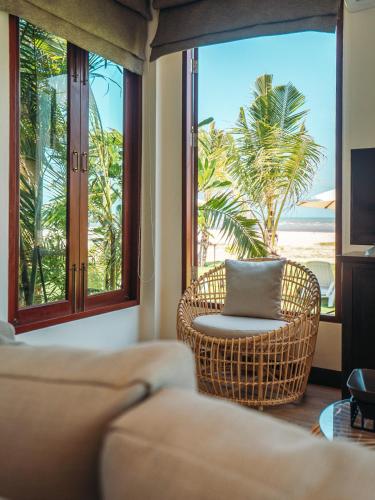 a living room with a couch and a view of the beach at Triple Tree Beach Resort in Cha Am