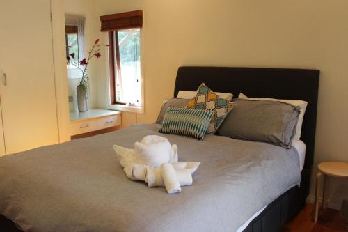 un animal de peluche sentado encima de una cama en Australian Home Away @ Wonga Park Brushy Creek, en Wonga Park