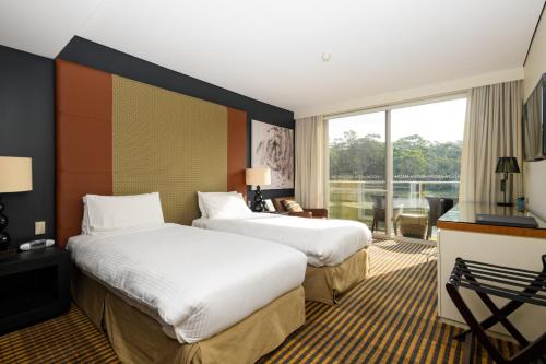 a hotel room with two beds and a balcony at MGSM Executive Hotel & Conference Centre in Sydney