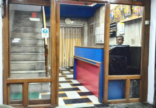 a man is sitting at a counter in a restaurant at Hotel Shiromani Palace Udaipur in Udaipur