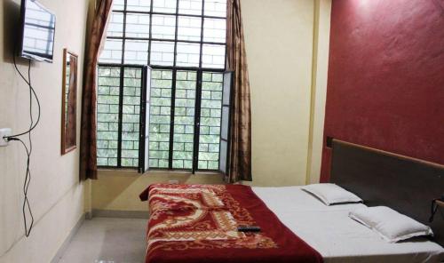 a bedroom with a bed and a large window at Hotel Shiromani Palace Udaipur in Udaipur
