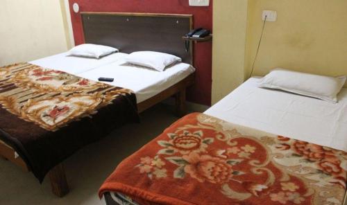 a room with two beds and a blanket on the bed at Hotel Shiromani Palace Udaipur in Udaipur