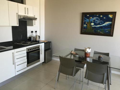 a kitchen with a table and a stove and a dining room at City Junction in Windhoek