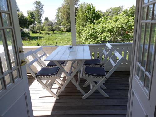 una mesa de picnic y sillas en un porche en Göta kanal Hajstorp, en Töreboda