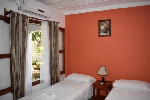 a room with two beds and a window at Benitez Hostería in Calilegua