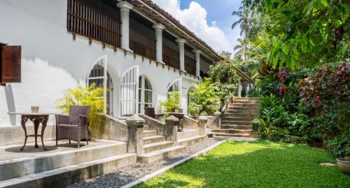 un patio de una casa con escaleras y césped en The Kandy House en Kandy