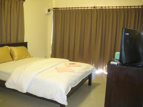 1 dormitorio con 1 cama y TV en una mesa en Naga Peak Resort, en Ao Nang Beach