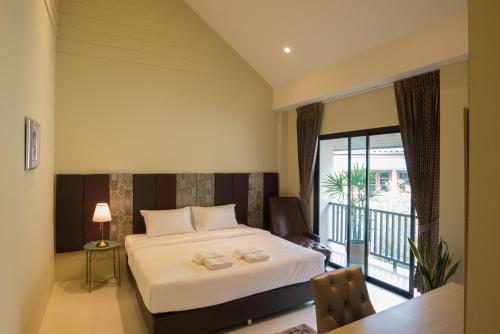 a hotel room with a bed and a balcony at Sri Ngachang in Chiang Mai