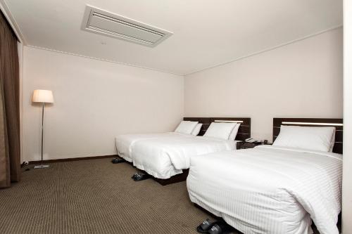 Ένα ή περισσότερα κρεβάτια σε δωμάτιο στο Busan Tourist Hotel