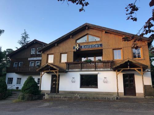 a large wooden building with a balcony on the front at Pension Raststüb'l in Sorge