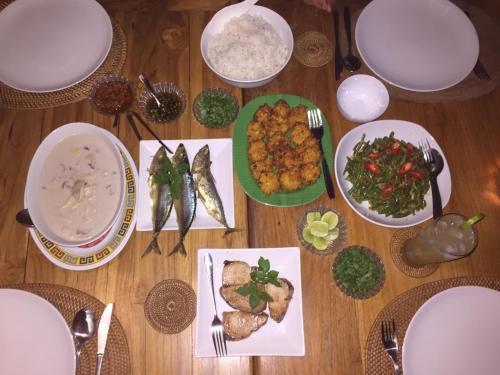 a wooden table with plates of food on it at Bali Sandat in Tejakula