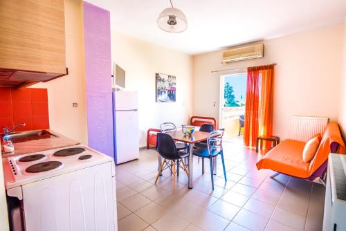 a kitchen and dining room with a table and chairs at Voula Apartments in Mitikas