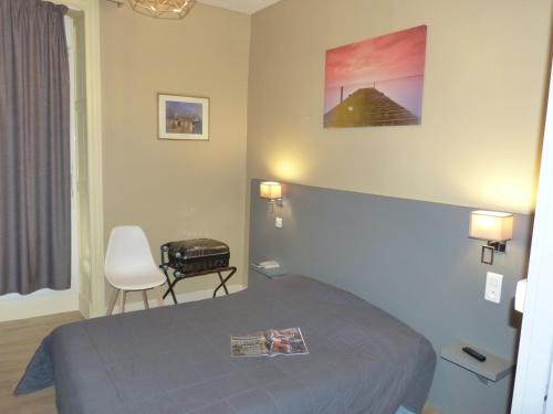 ナントにあるHôtel Terminusのベッドと椅子のあるホテルの部屋