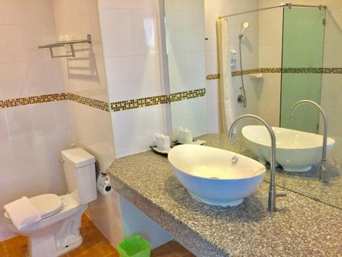 a bathroom with a bowl sink and a toilet at Tamali Hotel in Nakhon Si Thammarat