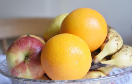 a bowl of fruit with oranges apples and bananas at Dale Street Apartments Suite in Leamington Spa