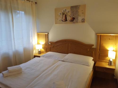 a bedroom with a large white bed with two lamps at Apartma Lenka Kranjska Gora in Kranjska Gora
