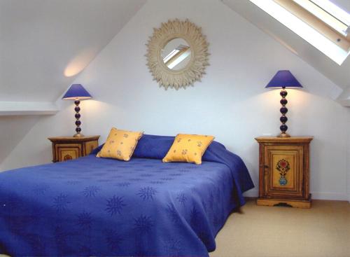 ein Schlafzimmer mit einem blauen Bett und einem Spiegel in der Unterkunft Résidence Hôtelière La Marine in Combleux