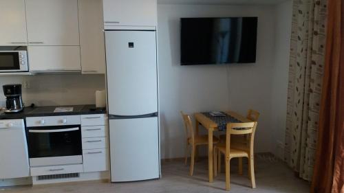 een keuken met een witte koelkast en een tafel met stoelen bij MR Apartments in Vaasa