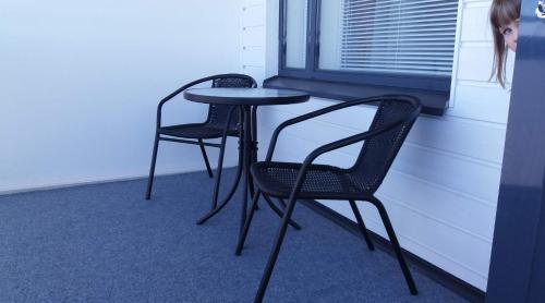two chairs and a table in a room with a window at MR Apartments in Vaasa
