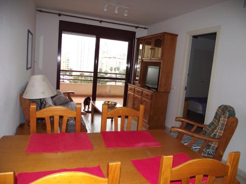 a dining room with a table and chairs and a cat at coral beach in Calpe
