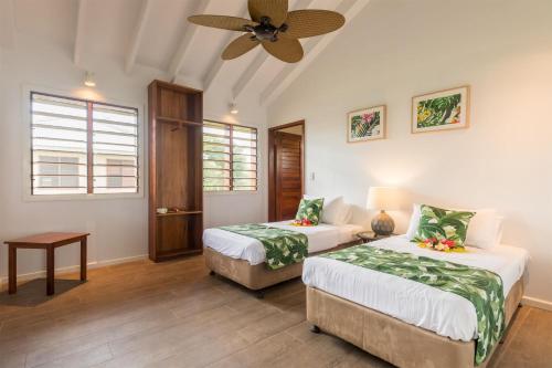 a bedroom with two beds and a ceiling fan at White Grass Ocean Resort & Spa in Tanna Island