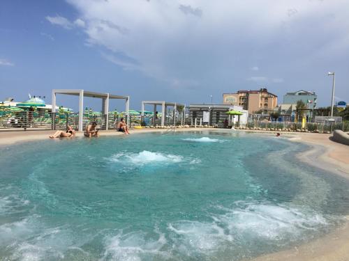 una grande piscina con persone in acqua di Residence Roxy a Misano Adriatico