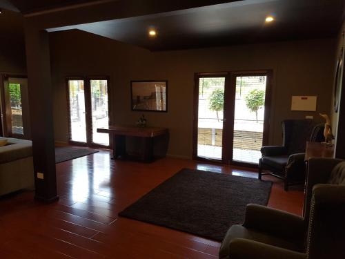 a living room with wooden floors and windows and a couch and chairs at Montrose Barn House- Entire Home in Montrose