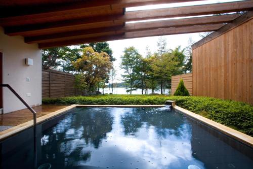 a swimming pool in the backyard of a house at Izumigo AMBIENT Tateshina Hotel in Tateshina