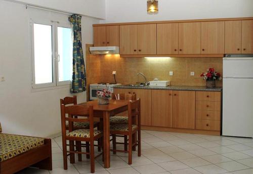 a kitchen with a table and chairs and a sink at Eleni Palace in Amoudara Herakliou