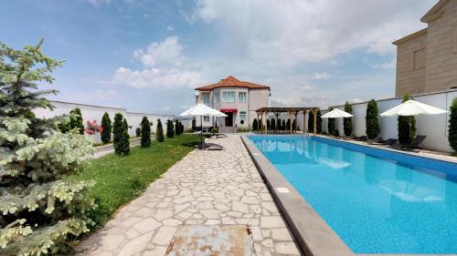 una piscina di fronte a un edificio con una casa di Ossanna Hotel a Yerevan