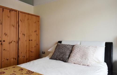 a bedroom with a bed and a wooden cabinet at Dale Street Apartments Suite in Leamington Spa