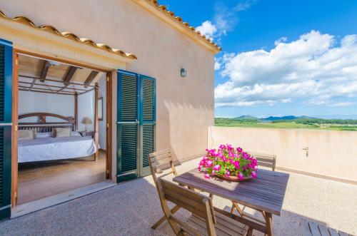 a room with a bed and a table with flowers at Angigal in Manacor