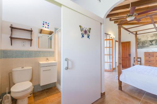a bathroom with a toilet and a bed at Angigal in Manacor