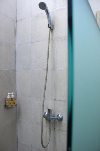 a shower with a shower head in a bathroom at Louto Dmell Villa & Guesthouse in Sanur