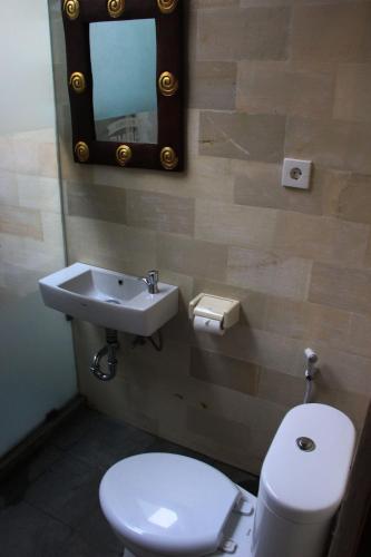 a bathroom with a white toilet and a sink at Louto Dmell Villa & Guesthouse in Sanur