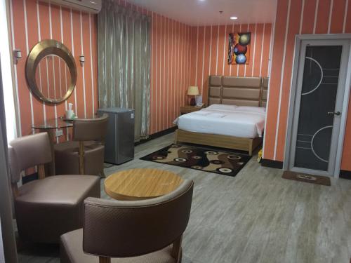 プエルト・プリンセサにあるJeamco Royal Hotel-Palawanのベッドルーム1室(ベッド1台、テーブル、椅子付)