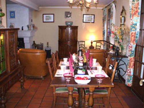 a dining room with a wooden table and chairs at Chambre d'Hôtes Quietude en Vallée de Chevreuse in Magny-les-Hameaux
