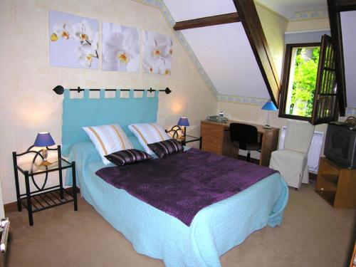 ein Schlafzimmer mit einem blauen Bett und einer lila Decke in der Unterkunft Chambre d'Hôtes Quietude en Vallée de Chevreuse in Magny-les-Hameaux