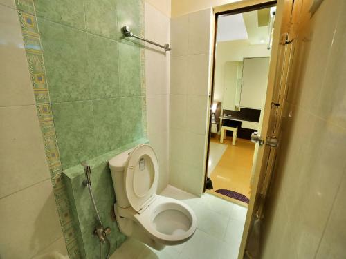 a bathroom with a toilet and a shower with a mirror at Hotel New Sree Krishna Residency in Hyderabad