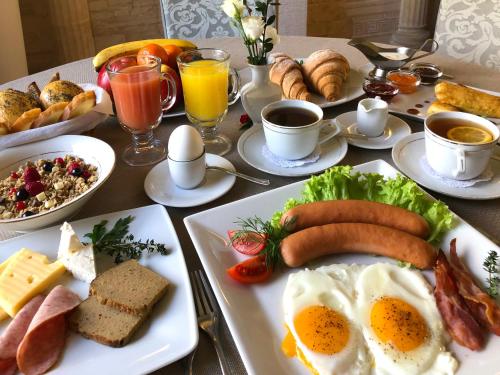 a table topped with plates of breakfast foods and drinks at Economy room in Hotel Eney in Lviv