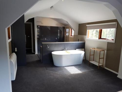 La salle de bains est pourvue d'une baignoire blanche et d'un lavabo. dans l'établissement Montrose Barn House, à Montrose