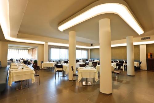 a dining room with white tables and chairs at Hotel Grifone in Principina a Mare