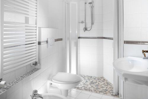 een witte badkamer met een toilet en een wastafel bij SoleMare Hotel e Residence in Misano Adriatico