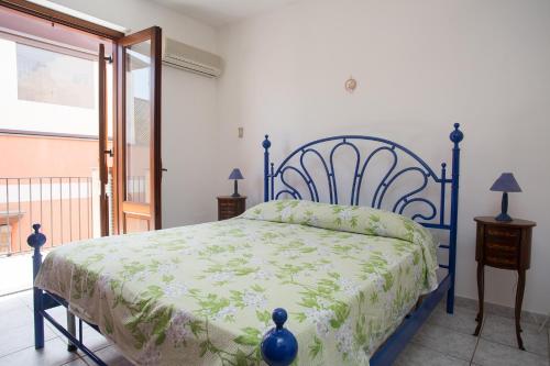 a bedroom with a blue bed with a green bedspread at La Bitta in Lipari