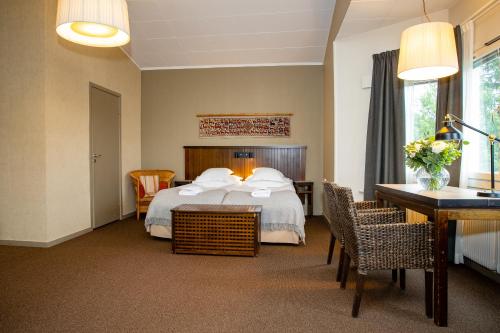 a hotel room with a bed and a table and chairs at Hotell Fjällgården Ski-In Ski-Out in Åre