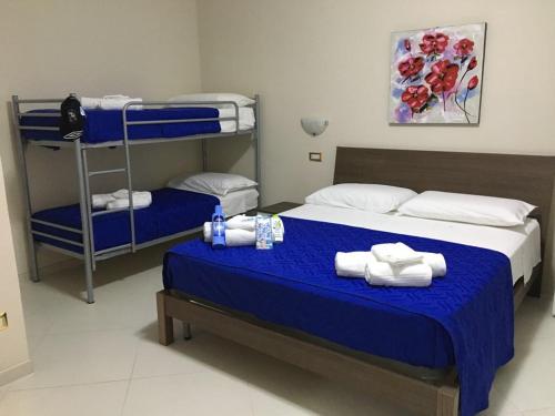 チレッラにあるB&B Riviera Azzurraのベッドルーム1室(ベッド2台、青いシーツ、タオル付)