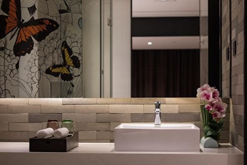 a bathroom with a white sink and a mirror at Paco Hotel Chebeinan Metro Guanghzou-Free Shuttle Bus For Canton Fair in Guangzhou