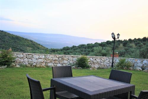 a table and chairs in a yard with a stone wall at Torre Bruno in Carpino